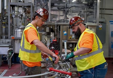 Two millwrights installing production lines for beverage production facility