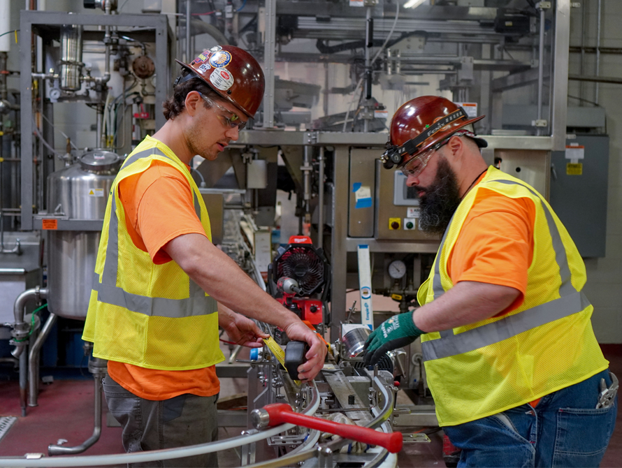 Two millwrights installing production line for food and beverage facility