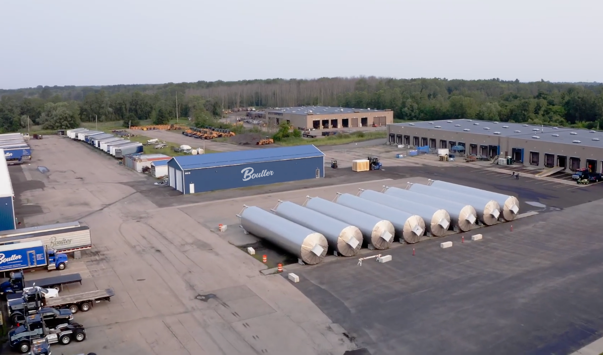 Large stainless steel tanks being stored in a yard